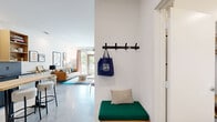 Located in Fayetteville, Arkansas, this one-bedroom, one-bathroom unit delivers a contemporary loft aesthetic across a compact yet efficiently designed single-floor layout. Polished concrete floors run throughout, lending an industrial-modern feel that ties each space together cohesively.

The open-concept kitchen and living area forms the heart of the unit. The kitchen features dark navy cabinetry paired with contrasting light wood upper cabinets and open shelving, black countertops, stainless steel appliances including a range and dishwasher, and a built-in range hood. A butcher block island with bar seating provides both additional prep space and casual dining. The adjoining living room is bright and airy, with recessed lighting, a glass door that opens to an outdoor area, and ample room for comfortable seating arrangements.

A hallway connects the main living area to the private bedroom, which benefits from large windows and a glass door bringing in natural light and outdoor views. A ceiling fan adds functionality to the well-proportioned room.

The bathroom maintains the clean, modern aesthetic with white subway tile surrounding a full tub-shower combination, a dark vanity with an integrated sink, and built-in open shelving for storage. The entryway includes a built-in bench and wall-mounted coat hooks, offering a practical and welcoming transition into the unit.