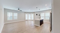 Located at 1100 Warburton Rd in Summerville, SC, this well-appointed single-story home offers 2 bedrooms and 2 bathrooms within a thoughtfully designed floor plan. Light wood-look flooring runs throughout, complemented by neutral gray-toned walls, crisp white trim, and recessed lighting that create a clean, contemporary aesthetic.

The open-concept kitchen and living area serves as the heart of the home. The kitchen features a large center island with a quartz countertop, an undermount sink with a matte black faucet, and bold pendant lighting. Two-tone cabinetry pairs dark lower cabinets with warm wood-toned uppers, accented by a white subway tile backsplash and stainless steel appliances. The adjacent living area is bright and spacious, with multiple windows and French doors that invite abundant natural light and outdoor views.

A central hallway connects the private quarters, where the generously sized primary bedroom includes multiple windows and ample closet space. The primary bathroom offers a dual-sink vanity with quartz countertops, dark cabinetry, a large mirror, and a separate water closet with a walk-in shower. The second bedroom is well-proportioned with natural light from surrounding windows. Three closets provide excellent storage throughout the home.