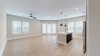 Located at 1100 Warburton Rd in Summerville, SC, this well-appointed single-story home offers 2 bedrooms and 2 bathrooms within a thoughtfully designed floor plan. Light wood-look flooring runs throughout, complemented by neutral gray-toned walls, crisp white trim, and recessed lighting that create a clean, contemporary aesthetic.

The open-concept kitchen and living area serves as the heart of the home. The kitchen features a large center island with a quartz countertop, an undermount sink with a matte black faucet, and bold pendant lighting. Two-tone cabinetry pairs dark lower cabinets with warm wood-toned uppers, accented by a white subway tile backsplash and stainless steel appliances. The adjacent living area is bright and spacious, with multiple windows and French doors that invite abundant natural light and outdoor views.

A central hallway connects the private quarters, where the generously sized primary bedroom includes multiple windows and ample closet space. The primary bathroom offers a dual-sink vanity with quartz countertops, dark cabinetry, a large mirror, and a separate water closet with a walk-in shower. The second bedroom is well-proportioned with natural light from surrounding windows. Three closets provide excellent storage throughout the home.
