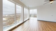 Located at 2200 Alpha Dr in Bridgeville, PA, this thoughtfully designed two-bedroom, two-bathroom residence offers a bright and contemporary single-floor layout. The open-concept kitchen and living area serves as the heart of the home, highlighted by floor-to-ceiling windows and a sliding glass door that lead to a private balcony with sweeping outdoor views. The kitchen is outfitted with crisp white shaker cabinetry, a herringbone tile backsplash, quartz countertops, open shelving, and a full suite of stainless steel appliances including a side-by-side refrigerator, electric range, dishwasher, and microwave. Warm luxury vinyl plank flooring flows consistently throughout the entire residence. The spacious primary bedroom includes a private en-suite bathroom and a generously sized walk-in closet with built-in wire shelving. The second bedroom benefits from natural light through a large window with outdoor views. Both bathrooms are clean and modern, with one featuring a full tub-shower combination and matte black fixtures. A dedicated laundry room with full-size washer and dryer adds everyday convenience. Stylish five-panel gray interior doors with matte black hardware lend a cohesive, contemporary aesthetic throughout the home.