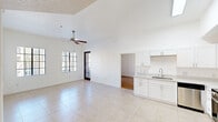 This single-story residence offers a thoughtfully designed layout combining comfort and functionality across one bedroom, two bathrooms, and three closets. The open-concept living and kitchen area immediately impresses with soaring vaulted ceilings and large windows fitted with blinds that allow abundant natural light to fill the space. Light-toned ceramic tile flooring extends throughout the main living area, complemented by a ceiling fan that enhances airflow in the generously proportioned living room.

The kitchen is well-equipped, featuring white shaker-style cabinetry, light countertops, a stainless steel sink, and a full suite of stainless steel appliances including a refrigerator, range, microwave, and dishwasher. Recessed overhead lighting adds brightness to the workspace.

The bedroom is a comfortable retreat finished with warm wood-look laminate flooring and a window offering natural light. It is served by a spacious walk-in closet outfitted with built-in shelving, hanging rods, and additional storage units — providing ample organizational capacity.

Both bathrooms are finished in white cabinetry and light countertops. One features a shower-tub combination with dark tile accents, while the other offers a sleek walk-in glass-door shower. An in-unit stacked washer and dryer is also conveniently located near the bathrooms, adding practical everyday functionality to this well-rounded residence.