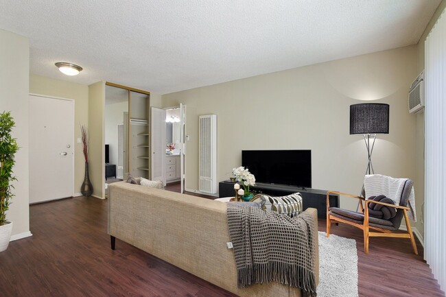 Wood-inspired floors in living room with a mirrored closet doors - Seville Townhouse