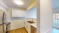 This single-floor residence offers a clean, contemporary living environment with a cohesive design aesthetic carried throughout every room. The kitchen stands out as a highlight, showcasing crisp white shaker cabinetry, marble-look countertops, a classic subway tile backsplash, and stainless steel appliances including a smooth-top electric range with a ventilation hood and a dishwasher. A pass-through opening connects the kitchen to the adjacent living area, creating an open, communicative flow between spaces.

The living and bedroom areas are finished with warm-toned wood-look flooring that extends consistently through the home, complemented by clean white walls and white baseboards that give the interior a bright, airy feel. Ceiling fans are present in multiple rooms, providing both comfort and light. The bedrooms offer comfortable proportions, with some rooms featuring natural light from windows with views to the outdoors.

Two bathrooms serve the residence, each finished with white vanity cabinetry, marble-look countertops, and a tub-shower combination. The overall palette remains neutral and inviting throughout. Ample closet storage is evident, with multiple paneled doors visible across the floor plan. The space presents a well-maintained, move-in ready environment with thoughtful, updated finishes.