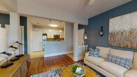 Located at 612 Council St in Wilmington, NC, this thoughtfully designed single-floor residence offers a comfortable and cohesive living experience. The open-concept living area immediately draws attention with its striking teal accent wall, rich hardwood flooring, and ample natural light streaming through large windows dressed with stylish drapes and blinds. A ceiling fan adds to the room's comfort, while the warm, coastal-inspired color palette creates a welcoming ambiance throughout.

The kitchen is both functional and attractive, featuring white shaker-style cabinetry, granite-look countertops, stainless steel appliances, a tile backsplash, and a convenient peninsula with pendant lighting that connects seamlessly to the living space. Tile flooring in the kitchen provides a clean transition from the hardwood in the main living area.

The bedrooms offer a serene retreat, with plush carpeting, shiplap accent walls, ceiling fans, and generous natural light. The primary bedroom is particularly inviting, with a spacious layout and coastal-themed décor.

The full bathroom is well-appointed with white cabinetry, granite countertops, a tiled tub-shower combination, and tile flooring. A dedicated laundry room houses a full-size washer and dryer with built-in shelving for added storage convenience.
