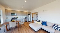 Located near the I-880 corridor in Oakland, CA, this contemporary multi-bedroom unit offers a thoughtfully designed single-floor layout that blends modern aesthetics with everyday functionality. The entry hallway features light wood-style flooring, recessed lighting, and clean white walls, setting a bright and welcoming tone throughout the space. The open-concept living, dining, and kitchen area serves as the heart of the unit, offering a generous and well-connected layout. The kitchen is equipped with stainless steel appliances including a gas range, microwave, dishwasher, and refrigerator, complemented by light wood cabinetry and clean countertops. Large floor-to-ceiling windows in the living and dining areas flood the space with natural light and frame views of the surrounding Oakland cityscape and highway infrastructure. A dedicated in-unit laundry area with a stacked washer and dryer adds convenience. Two well-proportioned bedrooms each feature carpeted floors, large windows with urban views, and ample natural light. The bathroom is finished in a clean, minimalist style with a combined tub and shower, tile flooring, and a modern vanity. Throughout the unit, the consistent use of light tones and contemporary finishes creates a cohesive, modern living environment.