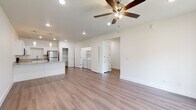 Located at 7805 SW Starling Ln in Bentonville, Arkansas, this single-story home offers a clean, modern design with a bright and cohesive aesthetic throughout. The open-concept living area is anchored by warm wood-look flooring, recessed lighting, and ceiling fans, creating a comfortable and functional atmosphere.

The kitchen is a standout feature, outfitted with crisp white shaker-style cabinetry, light granite countertops, a central island with additional prep space, and a full suite of stainless steel appliances including a refrigerator, range, microwave, and dishwasher. A built-in pantry provides generous storage just steps from the kitchen.

The bedrooms are well-proportioned, each equipped with ceiling fans and wood-look flooring. One bedroom includes a walk-in closet and a large window that brings in natural light with views of the surrounding neighborhood. The bathrooms mirror the home's design language, featuring white cabinetry, granite countertops, and full tub-shower combinations.

A dedicated laundry area with side-by-side washer and dryer units and overhead shelving adds everyday convenience. The home's consistent use of neutral tones, white trim, and modern finishes creates a cohesive, move-in-ready environment suited for comfortable single-floor living in Bentonville.
