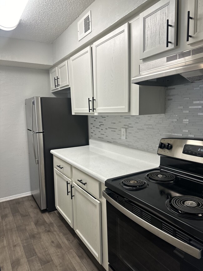 Galley Style Kitchen Featuring White Cabinetry - City West