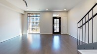 Located on Bainbridge Street in Richmond, Virginia, this contemporary multi-floor residence spans three levels and showcases thoughtfully curated finishes throughout. The kitchen is a standout feature, outfitted with gray shaker cabinetry accented by gold hardware, granite countertops, a white subway tile backsplash, stainless steel appliances, and a central island with pendant lighting — ideal for both cooking and entertaining. Rich hardwood flooring flows throughout the living areas, complementing the clean, neutral color palette.

The bedrooms are generously proportioned, each featuring ceiling fans and ample natural light from well-placed windows. Storage is a priority, with multiple bedrooms offering built-in closets and at least one walk-in closet equipped with wire shelving systems. The bathrooms are finished to a high standard: one features gray cabinetry with gold pulls, a granite vanity top, matte black fixtures, and a tub-shower combination, while another offers a sleek glass-enclosed walk-in shower with white subway tile and mosaic tile flooring. Tile flooring completes both bathrooms. The three-floor layout, visible in the architectural overview, provides distinct zones for living, sleeping, and additional utility, making this Richmond residence a well-appointed and functional urban home.
