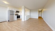 This well-appointed 3-bedroom, 2-bathroom unit in Toronto (M6L) offers a thoughtfully designed layout across a single floor, providing generous living space throughout. Light-toned laminate flooring flows seamlessly from room to room, complementing the bright, neutral colour palette that gives the entire unit an open, airy feel.

The entrance leads into a hallway that opens to a spacious combined living and dining area, bathed in natural light through wide windows. Two balconies extend the living space outdoors, offering views of the surrounding neighbourhood.

The kitchen is a standout feature, equipped with stainless steel appliances including a refrigerator, stove, microwave, and dishwasher. White shaker-style cabinetry, a white subway tile backsplash, and light stone countertops give the kitchen a clean, modern aesthetic. A peninsula-style counter adds additional workspace and separation from the main living area.

The generously sized primary bedroom offers ample space and dedicated closet storage. Two additional bedrooms, each with light-filled windows and closets, provide flexible space for family or guests. Four closets in total ensure excellent storage capacity throughout.

The bathrooms are finished in a clean, contemporary style, one featuring a soaker tub with white tile surround. A dedicated laundry room adds everyday convenience to this well-rounded home.