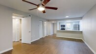 Located at 7610 W Waters Ave in Tampa, Florida, this single-floor, 2-bedroom, 2-bathroom residence offers a well-organized and functional layout. The open-concept living area is finished with wood-look flooring throughout and features a ceiling fan, a neutral color palette, and a sliding glass door that fills the space with natural light and provides access to a private outdoor area. The kitchen is positioned adjacent to the living room, separated by a half-wall pass-through counter. It is equipped with stainless steel appliances — including a refrigerator, electric range, microwave, and dishwasher — white cabinetry, and light countertops, all illuminated by overhead lighting. Two closets with louvered doors are conveniently located near the main living area. Both bedrooms feature wood-look flooring, ceiling fans, and windows with blinds that allow for natural light and outdoor views. Each bedroom includes a dedicated closet. The two bathrooms are finished with white tile surrounds — one featuring a full tub-shower combination, and the other a walk-in shower — each equipped with brushed nickel fixtures. The overall design is clean, practical, and move-in ready.