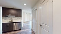 This contemporary 870 square foot apartment offers a well-designed living space with two bedrooms and two bathrooms. The open-concept layout seamlessly integrates the kitchen, living, and dining areas, creating a spacious feel. Large windows throughout flood the space with natural light and provide urban views.

The kitchen is a highlight, featuring sleek dark wood cabinetry, stainless steel appliances, and a stylish marble backsplash. The generous primary bedroom, measuring 210 square feet, provides ample space and includes a closet for storage. Both bathrooms are modern, with neutral-toned tiling and updated fixtures.

Throughout the apartment, warm-toned wood flooring adds a touch of elegance and continuity. A standout feature is the balcony access, offering an outdoor extension to the living space. The apartment's design maximizes functionality while maintaining a clean, minimalist aesthetic.

With its thoughtful layout and contemporary finishes, this apartment presents an ideal urban living solution, balancing comfort and style in its 870 square feet of living space.