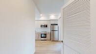 Located at 738 S Normandie Ave in Los Angeles, this thoughtfully designed 1-bedroom, 1-bathroom unit offers a clean, modern aesthetic throughout. Light wood flooring flows continuously across the open-plan layout, connecting the kitchen and living area in a bright, cohesive space. The kitchen is well-appointed with two-tone cabinetry — white upper cabinets paired with natural wood lower cabinets — complemented by a herringbone-patterned tile backsplash, white quartz countertops, a matte black faucet, and a full suite of stainless steel appliances including a refrigerator, range, microwave, and dishwasher. Natural light enters generously through large windows, with views of the surrounding neighborhood. The bedroom is a calm, minimal space featuring light wood floors, a large window, and two closets offering ample storage. The bathroom is finished with hexagonal floor tile in a classic cream-and-burgundy pattern, marble-style wall tile in the tub surround with a sliding glass door, and warm wood vanity cabinetry. Additional highlights include a private balcony, a dedicated laundry area, and a hallway that connects each space efficiently. The overall design is contemporary, clean, and well-suited for urban Los Angeles living.