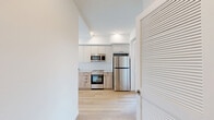 Located at 738 S Normandie Ave in Los Angeles, this thoughtfully designed 1-bedroom, 1-bathroom unit offers a clean, modern aesthetic throughout. Light wood flooring flows continuously across the open-plan layout, connecting the kitchen and living area in a bright, cohesive space. The kitchen is well-appointed with two-tone cabinetry — white upper cabinets paired with natural wood lower cabinets — complemented by a herringbone-patterned tile backsplash, white quartz countertops, a matte black faucet, and a full suite of stainless steel appliances including a refrigerator, range, microwave, and dishwasher. Natural light enters generously through large windows, with views of the surrounding neighborhood. The bedroom is a calm, minimal space featuring light wood floors, a large window, and two closets offering ample storage. The bathroom is finished with hexagonal floor tile in a classic cream-and-burgundy pattern, marble-style wall tile in the tub surround with a sliding glass door, and warm wood vanity cabinetry. Additional highlights include a private balcony, a dedicated laundry area, and a hallway that connects each space efficiently. The overall design is contemporary, clean, and well-suited for urban Los Angeles living.