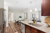 This 350 square foot studio apartment, located at 1950 Howell Mill Rd NW in Atlanta, GA, maximizes space efficiency with its thoughtful layout. The open-concept design features a modern kitchen equipped with stainless steel appliances, including a refrigerator, stove, microwave, and dishwasher. Rich wood cabinetry contrasts beautifully with white subway tile backsplash and light-colored countertops.

The living area is bathed in natural light from a set of French doors, offering a bright and airy ambiance. Warm-toned wood-look flooring extends throughout the space, providing a cohesive and inviting feel. The bathroom boasts contemporary fixtures, including a vanity with a granite countertop, a white bathtub with a shower, and sleek brown tile surround.

Despite its compact size, the apartment doesn't compromise on style or functionality. Ample storage solutions, including closets and kitchen cabinets, help maximize the available space. The property's single-floor layout and efficient design make it an ideal option for those seeking a low-maintenance, modern living space in a convenient Atlanta location.