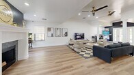 Located at 101 Chapel Ridge Dr in Union, MO, this single-floor community space offers a thoughtfully designed, open-concept layout that balances modern aesthetics with functional versatility. The interior is anchored by striking white decorative columns that define the space without sacrificing openness, complemented by warm light wood flooring that runs throughout the entire floor plan.

The living area serves as the heart of the space, featuring a bold accent wall with a classic fireplace, a mounted flat-screen television, and a seating arrangement centered around a checkered area rug that adds a dynamic visual element. Ceiling fans with recessed lighting provide both comfort and ambiance, while vaulted ceilings in portions of the space enhance the sense of openness.

Near the entrance, a welcoming reception-style zone greets visitors with a console table, curated wall art, and glass-paneled doors that allow natural light to filter in. A dedicated workstation area with computer equipment and a printer reflects the space's multi-functional character. A separate seating nook, a service counter area with cabinetry, and additional lounge furniture round out the interior. The contrast of crisp white walls against deep charcoal accent walls creates a contemporary and polished atmosphere throughout.