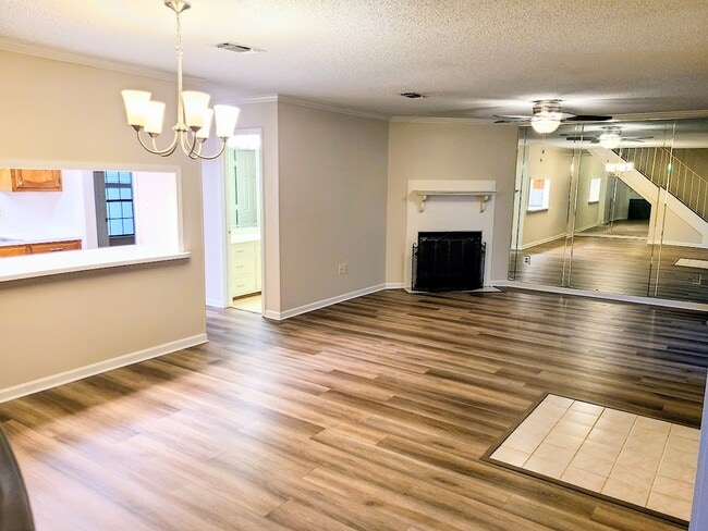 View from dining room to living room with woodburning fireplace - 12439 Coursey Blvd