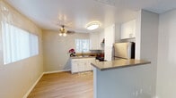 Located at 4300 Echo Ct in La Mesa, this single-floor unit offers a practical and well-maintained layout that connects living, dining, and kitchen areas in an open, flowing arrangement. Light wood-style flooring runs throughout the main living spaces, complementing the neutral warm-gray wall tones and white baseboards that create a clean, cohesive aesthetic. The living area receives natural light through a large sliding glass door fitted with vertical blinds, as well as an additional window, contributing to a bright and airy atmosphere. A wall-mounted air conditioning unit provides climate control.

The kitchen is thoughtfully designed with white shaker-style cabinetry, a double-basin sink beneath a window, and durable countertops. Stainless steel appliances include a gas range, dishwasher, and full-size refrigerator. A peninsula counter separates the kitchen from the living area, providing a natural division between the two spaces.

The bedroom features plush carpeting, a window with vertical blinds allowing natural light, and a sliding closet. The bathroom includes a single-basin vanity with a wide mirror and a walk-in shower enclosed by frosted sliding glass doors with stainless steel framing and grab bars.