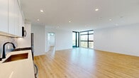 Located at 1112 Locust Ave in Long Beach, CA, this modern 2-bedroom, 2-bathroom unit offers a thoughtfully designed single-floor layout with clean, contemporary finishes throughout. Light wood flooring runs continuously across the space, complementing the crisp white walls and recessed lighting that enhance the bright, airy atmosphere.

The open-concept living room and kitchen area serves as the heart of the home. The kitchen is equipped with stainless steel appliances including a gas range, over-the-range microwave, and French door refrigerator, paired with white flat-panel cabinetry, quartz countertops, and a textured tile backsplash.

The primary bedroom is generously sized, featuring floor-to-ceiling black-framed windows that frame views of palm trees and offer abundant natural light. It includes access to a dedicated walk-in closet with built-in shelving rods. The second bedroom also benefits from large windows with neighborhood views and its own closet.

Both bathrooms are finished in a modern style with white subway tile, terrazzo-style flooring, and matte black hardware accents. One bathroom features a tub-shower combination enclosed by a frameless glass door, while the other includes a walk-in shower and a sleek vanity with a bold black-framed mirror. An in-unit stacked washer and dryer is also included.