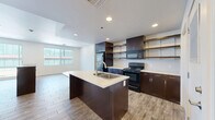 Located at 10 N Greenwood Ave in Tulsa, Oklahoma, this one-bedroom, one-bathroom unit offers a well-designed layout with modern finishes throughout. The open-concept living area seamlessly connects the kitchen, dining, and living spaces, creating an airy and functional environment. Wood-look tile flooring runs throughout the main living areas, adding warmth and continuity to the space.

The kitchen is a standout feature, anchored by a large central island with a double-basin sink and light-toned countertops that contrast elegantly with the rich, dark espresso cabinetry. Open metal shelving and upper cabinets provide generous storage, while black appliances — including a refrigerator, range, and microwave — complete the contemporary look. Recessed lighting illuminates the kitchen and dining area.

The living room receives natural light through large windows fitted with vertical blinds, and a ceiling fan adds comfort. The spacious bedroom also enjoys natural light via large windows and features wood-look flooring and a ceiling fan.

The bathroom is clean and modern, with a long dark-wood vanity, white countertop, large mirror, and tile flooring. Additional highlights include two closets, a dedicated pantry, and in-unit laundry for everyday convenience.