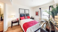Located in the heart of Los Angeles' Westlake neighborhood, this single-floor residence offers a thoughtfully designed layout that balances comfort and functionality. The open-concept living and dining area serves as the centerpiece of the home, featuring warm hardwood flooring, crown molding, and a sliding glass door that opens to a private balcony with views of the surrounding cityscape. The living space is bright and inviting, accommodating both a dining area with vibrant red seating and a comfortable lounge with ample room for relaxing. The kitchen is well-equipped with light wood cabinetry, granite countertops, a decorative tile backsplash, stainless steel appliances, and recessed lighting, with a breakfast bar providing additional seating and workspace. The primary bedroom is generously sized, offering hardwood floors, large windows, a walk-in closet, and direct access to a full bathroom featuring bold patterned wallpaper, a granite vanity, and a glass-enclosed shower. A second bedroom provides its own comfortable retreat with natural light and access to a second full bathroom complete with a shower-tub combination. Throughout the residence, curated artwork and lush indoor plants add warmth and personality to each room.