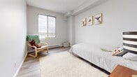 This thoughtfully designed 2-bedroom, 1-bathroom unit at 170 George St in Sarnia, Ontario offers a clean, modern aesthetic throughout its single-floor layout. A welcoming entryway with light wood-style flooring leads into a bright, open living room featuring large windows that frame expansive views of the surrounding cityscape — filling the space with natural light and a sense of openness.

The kitchen is well-equipped with crisp white shaker-style cabinetry, dark granite countertops, a classic subway tile backsplash, and stainless steel appliances including a range and full-size refrigerator. A convenient walk-in storage closet is accessible directly from the kitchen area.

The spacious primary bedroom is a comfortable retreat, featuring a large closet and light-toned flooring consistent with the rest of the unit. The second bedroom also benefits from a generous window with city views, providing a bright and functional space. Both rooms are finished with the same neutral, modern palette found throughout the home.

The bathroom is finished with full-height grey tile walls, a tub-shower combination, white vanity with storage, and a round mirror. Light tile flooring completes the clean, contemporary look. Overall, this unit offers a bright, functional, and stylishly updated living environment in the heart of Sarnia.