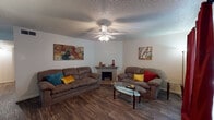Located in Lafayette, Louisiana, this two-bedroom, one-and-a-half-bathroom residence offers a thoughtfully designed single-floor layout that balances comfort and functionality. The living room serves as the heart of the home, featuring wood-look flooring, a corner fireplace with a classic surround, and a ceiling fan with light fixture overhead. A textured ceiling adds character throughout the common areas. Large drapes frame the windows, allowing for flexible light control and a warm ambiance.

The adjacent dining area is defined by a pendant light fixture that illuminates a generously sized dining table, making it well-suited for everyday meals and gatherings. The galley-style kitchen is efficiently laid out with dark cabinetry, light countertops, a double stainless steel sink, and a full suite of appliances including a refrigerator and dishwasher.

Both bedrooms are carpeted and feature ceiling fans, windows with blinds, and ample room for full bedroom furniture sets. The primary bedroom includes a dresser and offers a calm, restful atmosphere. The half bathroom features wood-look flooring, a vanity with a sink, and clean, neutral finishes. Throughout the home, the neutral color palette and practical layout make for a comfortable and move-in ready living space.