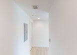 Located at 1500 NE Miami Place in the heart of Miami, FL, this modern single-floor unit offers a clean, contemporary design throughout. Light wood-tone flooring runs continuously across the living areas, creating a bright and cohesive aesthetic complemented by crisp white walls and recessed lighting.

The open-concept living and kitchen area serves as the centerpiece of the unit. The kitchen is outfitted with flat-front cabinetry in a warm taupe finish, granite countertops, and a full suite of stainless steel appliances including a range, over-the-range microwave, dishwasher, and a French door refrigerator. The seamless layout connects the kitchen directly to the spacious living area, which is bathed in natural light from large sliding glass doors that open to a balcony with sweeping panoramic views of the Miami skyline and surrounding cityscape.

The bedroom continues the light, airy feel with a large window framing elevated city views and a generous closet. The bathroom features a full soaking tub and shower combination, highlighted by elegant marble-patterned wall surrounds with chrome fixtures. A utility corridor provides access to the electrical panel and additional building systems. The overall ambiance is clean, modern, and move-in ready, reflecting contemporary urban living in a prime Miami location.