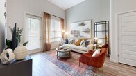 Located at 4805 Creek Cir in Cumming, GA, this one-bedroom, one-bathroom residence offers a thoughtfully designed single-floor layout that maximizes both comfort and functionality. The open-concept kitchen is a standout feature, showcasing crisp white shaker cabinetry extending to dramatic ceiling heights, granite countertops, a large center island with bar seating, and a full suite of stainless steel appliances including a gas range, microwave, and French door refrigerator. Pendant lighting above the island adds a refined touch. The living room is bathed in natural light through oversized windows and a glass-panel exterior door, framed by warm drapes that complement the light wood-look flooring carried throughout the main living areas. Soaring ceilings amplify the sense of openness in both the kitchen and living spaces. The bedroom is a serene retreat featuring plush carpet, elevated ceilings, a natural light-filled window, and a dedicated closet for storage. The bathroom continues the home's cohesive aesthetic with white cabinetry, granite countertops, a well-lit vanity mirror, and built-in open shelving. A stacked in-unit washer and dryer closet adds everyday convenience, rounding out this well-appointed and move-in-ready residence.