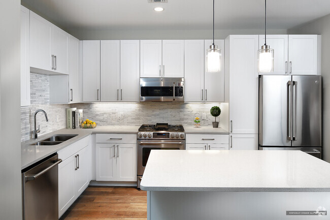 Signature Collection kitchen with white cabinetry, light grey quartz countertops, white marbled subway tile backsplash, stainless steel appliances, and hard surface flooring - Avalon Rockville Centre