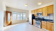 Located at 2030 Dwight Way in Berkeley, CA, this one-bedroom, one-bathroom unit offers a well-designed layout that makes efficient use of its compact footprint. The open-plan living and kitchen area is the heart of the unit, bathed in natural light streaming through a bank of multi-pane windows that frame views of the surrounding Berkeley neighborhood. Light hardwood-style flooring runs throughout, lending a clean and cohesive aesthetic to the space.

The kitchen is thoughtfully equipped with warm honey-toned wood cabinetry, dark granite-style countertops, and a full suite of stainless steel appliances, including a gas range, microwave, and refrigerator. A tile backsplash adds a subtle decorative touch. An arched entryway provides a charming architectural detail that connects the main living area to the private spaces beyond.

The bedroom is a serene, light-filled retreat with multiple windows and a mirrored sliding-door closet that adds depth to the room. Two closets in total provide ample storage throughout the unit.

The bathroom features classic penny tile flooring, wainscoting-height subway tile walls with a decorative border, a granite-topped vanity with an undermount sink, and a windowed tub-shower combination, lending a timeless character to the space. The overall ambiance is bright, clean, and functional.
