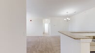 Located at 4229 Stonecrest Dr in Burlington, NC, this single-story home offers three bedrooms and three full bathrooms thoughtfully arranged across a well-proportioned floor plan. The open-concept kitchen and living area serve as the heart of the home, featuring warm honey-toned wood cabinetry, granite-style countertops, a peninsula with a built-in sink, and black appliances including a range, dishwasher, and microwave. An elegant chandelier above the dining area complements the pendant lighting, while light hardwood flooring runs through the kitchen and bathrooms. The living room is bright and inviting, with plush neutral carpet, a ceiling fan, and large windows with blinds that allow ample natural light. A glass-paned exterior door adds additional brightness to the space. Each of the three carpeted bedrooms includes a ceiling fan and generous closet space, with the primary bedroom offering a notably spacious layout and a dedicated double-door closet. The primary bathroom features a dual-sink vanity with warm wood cabinetry, white countertops, a large mirror, and hardwood-style flooring. Additional bathrooms mirror the clean, functional design with single vanities and tub-shower combinations. A hallway connects the bedrooms, with a dedicated closet providing extra storage throughout this comfortable and well-appointed home.