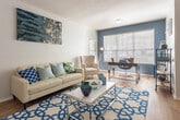Located at 945 S Mesa Hills Dr in El Paso, Texas, this single-floor residence offers a thoughtfully designed open-concept layout that seamlessly connects the living, dining, and kitchen areas. The living room is a welcoming focal point, featuring warm hardwood-style flooring, a ceiling fan, and generous natural light. A bold navy-and-white geometric accent wall adds a striking visual element that flows between the living and dining spaces, creating a cohesive and contemporary aesthetic throughout.

The kitchen is well-appointed with rich dark cabinetry, stainless steel appliances including a refrigerator and range, and a prominent marble-style countertop island that provides additional workspace and casual seating. The same eye-catching chevron wallpaper continues into the kitchen, reinforcing the unit's modern design language.

The bedroom is carpeted for comfort and features natural light through a window with blinds, a ceiling fan, and ample wall space. A second flexible room with hardwood-style flooring and large windows offers potential for use as a home office or additional bedroom.

The bathroom includes a full tub-shower combination with clean white tile and access to a walk-in closet, providing practical storage. Throughout the space, the consistent use of bold accent colors, quality finishes, and an open floor plan come together to create a vibrant and functional living environment.