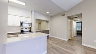 Located at 700 N Coronado St in Chandler, AZ, this well-appointed 2-bedroom, 2-bathroom residence offers a thoughtfully designed single-level layout. The open living room is a standout space, featuring soaring vaulted ceilings, a ceiling fan, a tile-surround fireplace, and sliding glass doors that lead to an outdoor balcony, filling the room with natural light and views of the surrounding neighborhood. A built-in arched niche adds an architectural touch to the living area.

The kitchen is finished with white upper cabinetry, gray lower cabinetry, quartz countertops, a stainless steel sink, and a full suite of stainless steel appliances including a refrigerator, range, microwave, and dishwasher. A peninsula island provides additional prep and serving space, connecting the kitchen to the living area.

Both bedrooms feature vaulted ceilings, ceiling fans, wood-style plank flooring, and ample natural light from large windows. The spacious primary bedroom includes access to a dedicated closet. Each of the two bathrooms is finished with quartz countertops, gray vanity cabinetry, a large mirror, and a glass-enclosed shower. Wood-style flooring extends through both bathrooms. Three closets provide generous storage throughout the home.