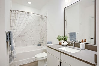 Marble-look tile and a deep bathtub elevate the everyday. Enjoy the BH-A1 floor plan's clean, modern bathroom at Garrett Harvest Junction West, Longmont, CO. - Garrett Harvest Junction West