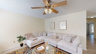 Located at 950 Travelers Blvd in Summerville, SC, this single-floor, 2-bedroom, 2-bathroom home offers a well-organized layout designed for comfortable everyday living. The open living room is bright and inviting, featuring light wood-style flooring, a textured ceiling, and a ceiling fan with integrated lighting. A front entry door with sidelight windows allows natural light to fill the space. The adjoining dining area is generously sized, complete with its own ceiling fan and a window that brings in additional natural light. The galley-style kitchen is efficiently designed with white cabinetry, granite-style countertops, and a full suite of stainless steel appliances, including a refrigerator, range, microwave, and dishwasher. The spacious primary bedroom features sliding glass doors that open to an outdoor view, a ceiling fan, and light wood flooring. The second bedroom is equally well-appointed, with a ceiling fan and ample space. Both bathrooms are clean and functional, each featuring a tub-shower combination, vanity with storage, and light flooring. A hallway and dedicated closet provide practical storage solutions throughout. The home's neutral color palette and consistent flooring create a cohesive, move-in-ready atmosphere.