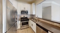 Located at 10125 Palms Blvd in the Palms neighborhood of Los Angeles, this single-story unit showcases a thoughtfully updated interior with a clean, contemporary aesthetic throughout. Crown molding and recessed lighting are consistent features across the main living areas, lending a polished, cohesive feel.

The open-concept living and dining area is bright and spacious, anchored by a striking stone-surround fireplace that serves as a focal point. Light-toned hardwood-style flooring flows seamlessly through the main living spaces, complementing the neutral wall tones. A sliding glass door in the dining area invites natural light and provides access to an outdoor space.

The kitchen is well-appointed with white shaker cabinetry, dark countertops, a mosaic tile backsplash, and a full suite of stainless steel appliances including a gas range, built-in microwave, refrigerator, and dishwasher. A breakfast bar connects the kitchen to the living area, enhancing the open layout.

The bedrooms feature plush carpeting, crown molding, ceiling fans, and accent walls in cool gray tones, with plantation shutters providing privacy and light control. The bathroom includes a white vanity with a dark countertop, recessed medicine cabinet, and hardwood-style flooring that continues from the hallway, with an adjacent walk-in closet offering generous storage.
