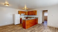 Located at 3617 E Uintah St in Colorado Springs, Colorado, this single-floor unit offers a practical and functional layout designed for comfortable everyday living. Wood-look plank flooring flows consistently throughout the space, providing a cohesive and easy-to-maintain surface.

The kitchen serves as a central feature of the home, showcasing warm honey-toned cabinetry with ample upper and lower storage, granite-look countertops, and a peninsula that doubles as a prep area and informal dining space. White appliances — including a refrigerator, electric range, and dishwasher — are included. A stainless steel sink is positioned within the peninsula for added convenience, and an under-cabinet range hood is installed above the stove.

Adjacent to the kitchen, the open living area benefits from natural light through a window fitted with blinds, and baseboard heating ensures year-round comfort. The bedroom is a well-proportioned room featuring its own window with blinds, a closet with bifold doors providing solid storage space, and the same wood-look flooring found throughout. The bathroom includes a full tub-and-shower combo with white tile surround and chrome fixtures. The overall layout is straightforward and efficiently organized, making this a well-appointed single-level residence in Colorado Springs.