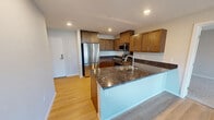 This contemporary 900 square foot apartment offers a well-designed living space with three bedrooms and one bathroom. The heart of the home is a spacious open-concept kitchen and living area, perfect for both entertaining and everyday living. The kitchen boasts sleek stainless steel appliances, ample wood cabinetry, and elegant granite countertops, creating a stylish and functional cooking space.

Large windows throughout the apartment flood the rooms with natural light, enhancing the sense of space and creating a bright, airy atmosphere. The primary bedroom, measuring 170 square feet, provides a generous retreat with plush carpeting and a walk-in closet. Two additional bedrooms offer versatility for a growing family or home office needs.

The modern bathroom features a combination tub-shower unit with a curved shower rod, wood-look flooring, and a single vanity. For added convenience, the apartment includes an in-unit laundry room with full-size washer and dryer. The neutral color palette and mix of carpet and wood-look flooring throughout create a cohesive, contemporary feel that allows for personalized décor. Located in Fridley, MN, this apartment combines modern amenities with a practical layout, making it an ideal home for various lifestyles.