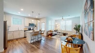Located at 12609 Matisse Cir in New Port Richey, FL, this single-story home offers a thoughtfully designed open-concept layout filled with natural light. The living area features wood-look flooring, a ceiling fan, and large windows with blinds that invite abundant daylight, creating a bright and airy atmosphere.

The kitchen is a standout feature, showcasing white shaker cabinetry, granite countertops, a tile backsplash, and a full suite of stainless steel appliances including a refrigerator, range, microwave, and dishwasher. A central island with seating provides additional prep space and a casual dining option, complemented by stylish pendant lighting overhead.

The primary bedroom is a comfortable retreat with a ceiling fan, natural light from a large window, a walk-in closet, and a private en-suite bathroom featuring a granite vanity, white cabinetry, and a glass-enclosed shower. A second bedroom offers similar finishes with ample natural light and wood-look flooring. The second bathroom mirrors the home's modern aesthetic with a granite vanity and a tub-shower combination with tile surround.

Throughout the home, consistent finishes including neutral tones, recessed lighting, and quality materials create a cohesive and welcoming environment well-suited for comfortable Florida living.
