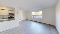 Located at 7555 Goreway Drive in Mississauga, Ontario, this two-storey residence offers a well-organized layout across two floors, with the main level providing communal living spaces and the upper level dedicated to private quarters. The ground floor features an open living area with light-toned laminate wood flooring that extends throughout, a large picture window that fills the space with natural light, and a connected kitchen equipped with appliances including a microwave and stove. A tiled entryway welcomes you at the front door, leading seamlessly into the main living area. The upper floor hosts three bedrooms, including a generously sized primary bedroom, each outfitted with sliding closet doors — one set finished with mirrored panels for a spacious feel. Bedrooms benefit from large windows and sliding glass doors that open to outdoor views of the surrounding greenery and neighbourhood. The bathroom is finished with marble-style tile flooring, a white vanity with cabinetry, and a tiled shower-tub combination, maintaining a clean and bright aesthetic. Multiple hallways connect the layout efficiently across both floors. A utility room and additional unclassified spaces offer practical storage and functional flexibility. The overall interior presents a clean, neutral palette throughout.