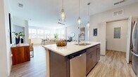 Located at 9357 Old Union Rd in Union, Kentucky, this single-floor, 3-bedroom, 4-bathroom home offers a thoughtfully designed open-concept layout with contemporary finishes throughout. The combined kitchen and living area serves as the heart of the home, anchored by a large central island with a quartz countertop, undermount sink, and stainless steel dishwasher. Elegant glass pendant lights hang above the island, while rich dark-toned cabinetry lines the kitchen walls alongside a classic subway tile backsplash. Stainless steel appliances, including a refrigerator, range, and built-in microwave, complete the culinary space. The living area flows seamlessly from the kitchen, bathed in natural light from multiple windows, with light hardwood-style flooring extending throughout the main areas. The three bedrooms offer comfortable retreats, with plush carpeting and generous closet space, including a spacious walk-in closet with wire shelving. Four well-appointed bathrooms provide ample convenience, with one featuring a full tub and tiled surround. A dedicated laundry area and utility space with a water heater and tankless system round out the functional layout, making this home as practical as it is stylish.