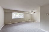 Located at 6501 Hil Mar Dr in District Heights, MD, this single-floor, two-bedroom unit offers a practical and comfortable layout designed to maximize everyday livability. The expansive living room serves as the heart of the space, featuring soft wall-to-wall carpeting, a ceiling fan with light fixture, a large picture window that invites generous natural light, and views of the surrounding greenery outside.

The primary bedroom is generously sized, also finished with plush carpeting and a wide window fitted with blinds that allow for natural light and outdoor views. The second bedroom mirrors this design with its own window and a built-in closet with bifold doors, providing convenient storage. Three closets in total are distributed throughout the unit, offering ample storage solutions.

The kitchen is outfitted with light wood-toned cabinetry, speckled countertops, tile flooring, and a black refrigerator, providing a clean, functional workspace. The bathroom features a full tiled tub-shower combination in a bright, white finish. Neutral beige tones, white trim, and textured ceilings carry throughout the unit, creating a cohesive and understated aesthetic. A connecting hallway ties all rooms together, making the floor plan easy to navigate.