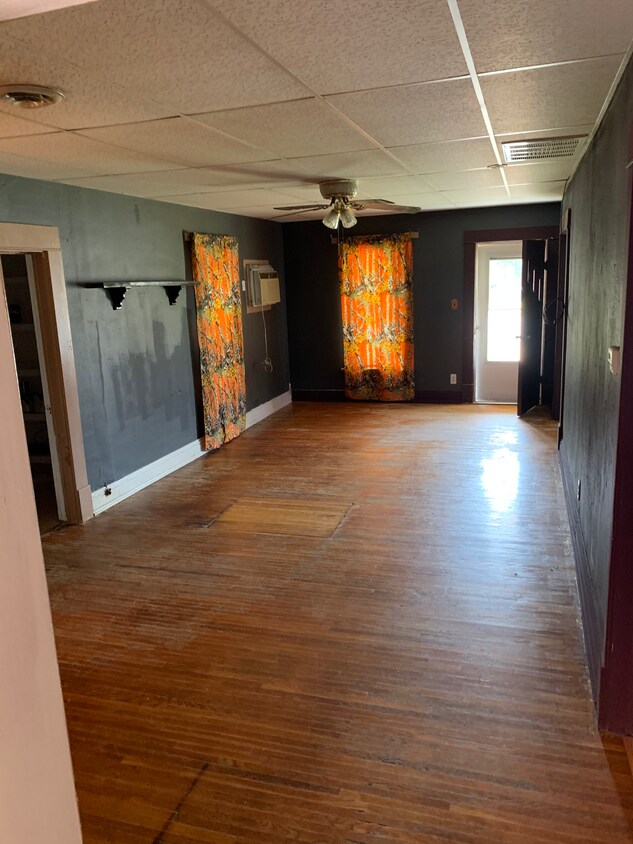 Living room from kitchen. Nice ceiling fan, ice cold window AC unit in the far corner. An additional window AC is included to put into a bedroom or the kitchen. - 410 Church St.