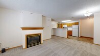 Located at 1150 Northwood Dr in Eagan, MN, this one-bedroom, one-bathroom unit offers a well-organized and functional single-floor layout. The open-concept living and dining area is highlighted by a wood-trimmed fireplace, plush wall-to-wall carpeting, and large windows that invite natural light and provide views of the surrounding exterior. A tiled entryway near the front door creates a clean transition into the carpeted living space.

The kitchen flows directly off the living area and features warm oak cabinetry, white appliances including a refrigerator, electric range, and built-in microwave, as well as a peninsula counter that serves as a natural divider between the kitchen and living space. The tile flooring in the kitchen adds durability and contrast to the overall design.

The bedroom is a comfortable, well-proportioned room with carpet flooring, a window allowing natural light, and neutral walls that provide a versatile backdrop. The full bathroom includes an oak vanity, tile flooring, and a full-size bathtub with a shower rod. A dedicated utility room houses the mechanical systems, adding practicality to the layout. Throughout the unit, warm wood trim and neutral tones create a cohesive and welcoming atmosphere.
