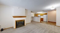 Located at 1150 Northwood Dr in Eagan, MN, this one-bedroom, one-bathroom unit offers a well-organized and functional single-floor layout. The open-concept living and dining area is highlighted by a wood-trimmed fireplace, plush wall-to-wall carpeting, and large windows that invite natural light and provide views of the surrounding exterior. A tiled entryway near the front door creates a clean transition into the carpeted living space.

The kitchen flows directly off the living area and features warm oak cabinetry, white appliances including a refrigerator, electric range, and built-in microwave, as well as a peninsula counter that serves as a natural divider between the kitchen and living space. The tile flooring in the kitchen adds durability and contrast to the overall design.

The bedroom is a comfortable, well-proportioned room with carpet flooring, a window allowing natural light, and neutral walls that provide a versatile backdrop. The full bathroom includes an oak vanity, tile flooring, and a full-size bathtub with a shower rod. A dedicated utility room houses the mechanical systems, adding practicality to the layout. Throughout the unit, warm wood trim and neutral tones create a cohesive and welcoming atmosphere.
