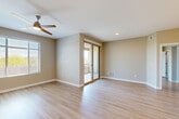 Located in Peoria, Arizona, this single-floor, 3-bedroom, 2-bathroom residence offers a thoughtfully designed layout with consistent, modern finishes throughout. Light wood-tone flooring runs seamlessly across the entire space, complemented by neutral warm-gray walls and clean white trim that create a bright, cohesive aesthetic.

The open-concept living area is generously proportioned, featuring a ceiling fan, recessed lighting, and large sliding glass doors that flood the space with natural light and provide direct access to an outdoor balcony with views of the surrounding Arizona landscape. The kitchen is a standout, boasting granite countertops, a large peninsula with an undermount sink, white cabinetry, a subway tile backsplash, stainless steel appliances, and stylish pendant lighting. A dedicated laundry room with a full-size washer and dryer is conveniently accessible from the kitchen.

The three bedrooms are well-sized and comfortable, each equipped with ceiling fans. The spacious primary bedroom includes an en-suite bathroom and direct balcony access via sliding glass doors. The bathrooms are finished with granite countertops, white subway tile shower surrounds, and modern fixtures. A dedicated hallway, entrance, and closet round out this functional and attractive single-level home.