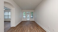 Located at 1924 Monroe Dr NE in Atlanta's vibrant Midtown neighborhood, this well-appointed one-bedroom, one-bathroom unit offers a thoughtfully designed single-floor layout with modern finishes throughout. Rich hardwood-style flooring flows seamlessly across every room, complementing the clean, neutral palette of crisp white walls and bright white trim.

The open-concept kitchen and living area serves as the heart of the unit. The kitchen is outfitted with white shaker cabinetry, black hardware accents, a subway tile backsplash, quartz countertops, a peninsula with an undermount sink and matte black faucet, and a full suite of stainless steel appliances including a French door refrigerator, range, microwave, and dishwasher. Pendant lighting adds a modern touch overhead. The adjacent living area benefits from a private entry door and generous windows that frame lush green tree views, filling the space with natural light.

The spacious bedroom features dual windows, a ceiling fan, and access to a walk-in closet equipped with wire shelving on multiple walls for ample storage. The bathroom is finished with white subway tile surrounding a soaking tub and shower combination, black fixtures, a white vanity, and coordinating hardwood-style flooring. An elegant arched hallway passageway adds an architectural charm that ties the layout together cohesively.