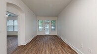 Located at 1924 Monroe Dr NE in Atlanta's vibrant Midtown neighborhood, this well-appointed one-bedroom, one-bathroom unit offers a thoughtfully designed single-floor layout with modern finishes throughout. Rich hardwood-style flooring flows seamlessly across every room, complementing the clean, neutral palette of crisp white walls and bright white trim.

The open-concept kitchen and living area serves as the heart of the unit. The kitchen is outfitted with white shaker cabinetry, black hardware accents, a subway tile backsplash, quartz countertops, a peninsula with an undermount sink and matte black faucet, and a full suite of stainless steel appliances including a French door refrigerator, range, microwave, and dishwasher. Pendant lighting adds a modern touch overhead. The adjacent living area benefits from a private entry door and generous windows that frame lush green tree views, filling the space with natural light.

The spacious bedroom features dual windows, a ceiling fan, and access to a walk-in closet equipped with wire shelving on multiple walls for ample storage. The bathroom is finished with white subway tile surrounding a soaking tub and shower combination, black fixtures, a white vanity, and coordinating hardwood-style flooring. An elegant arched hallway passageway adds an architectural charm that ties the layout together cohesively.