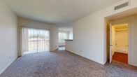 Located at 3801 N McColl Rd in McAllen, Texas, this single-floor unit offers a thoughtfully arranged layout with a bright, open feel throughout. The living area is carpeted and bathed in natural light, featuring large vertical-blind-covered sliding glass doors that open to outdoor views of lush greenery, creating a seamless connection between indoor and outdoor living. A pass-through counter separates the living space from the kitchen, which is outfitted with dark countertops, white cabinetry, wood-look flooring, and includes appliances such as a refrigerator and dishwasher. An adjacent utility area provides added convenience. The dining area features wood-look flooring and receives generous natural light through a dedicated window. The bedrooms are carpeted and generously sized, each featuring ceiling fans and large windows that invite abundant natural light. One bedroom includes a walk-in closet with built-in shelving, while the other offers direct access to a full bathroom. The bathroom is appointed with a tiled tub-shower combination, a vanity with cabinetry, and wood-look flooring. The entry foyer is welcoming and opens naturally into the main living space, completing a functional and comfortable floor plan.