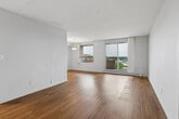 Located on the 8th floor at 350 Elliott St in Windsor, Ontario, this 2-bedroom, 1-bathroom unit offers a practical and well-appointed layout across a single floor. Warm-toned hardwood-style flooring flows consistently throughout the living areas and bedrooms, lending a cohesive and inviting feel to the space.

The living room is the heart of the unit, featuring a large sliding glass door that opens to a private balcony with outdoor views, allowing for generous natural light. A pendant light fixture adds a simple decorative touch, while baseboard heating ensures year-round comfort. The open feel of the living area provides versatile space for both relaxing and entertaining.

The primary bedroom is a well-sized room with its own window overlooking the surrounding neighbourhood, a baseboard heater, and a full-width double closet with sliding doors — offering ample storage. The second bedroom also features a window with natural light, hardwood-style flooring, vertical blinds, and a baseboard heater.

The bathroom is finished with classic white subway tile surrounding a full soaker tub and shower combination, fitted with polished chrome fixtures for a clean and timeless look.

A hallway connects the rooms efficiently, and the unit's neutral white walls and textured ceilings throughout provide a clean, move-in-ready canvas.